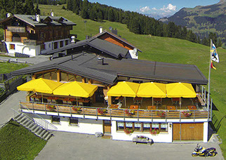 Bildbeschreibung: sommerliche Aussenaufnahme mit aufgespannten Sonnenschirmen auf der grossen Terrasse.